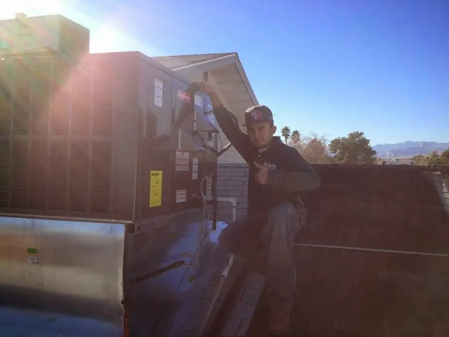HVAC technician performing Boiler Repair on a rooftop unit in Smithville